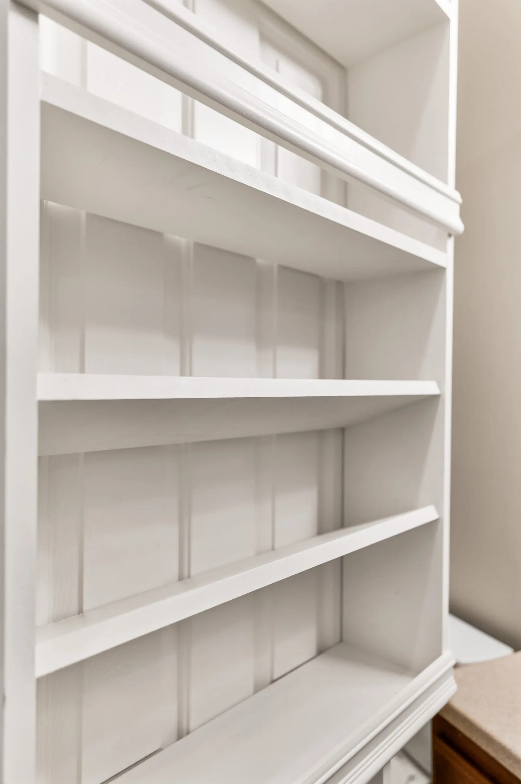 Vertical white shelving unit, no items.