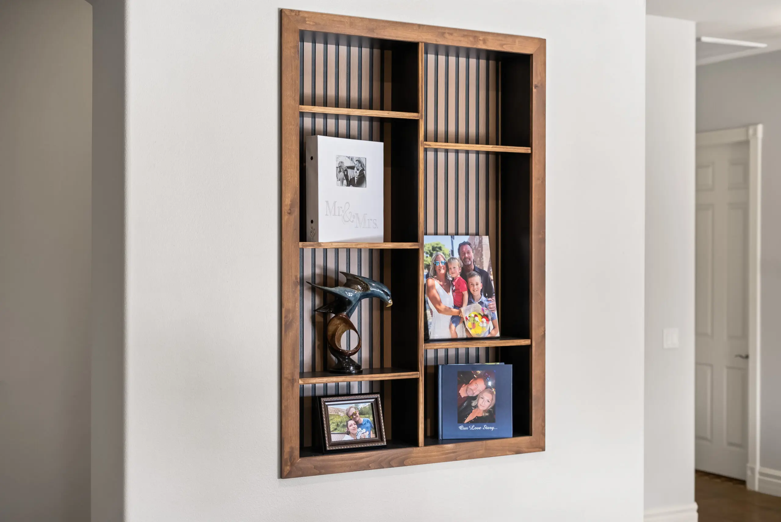 Wall-mounted shelf displaying family portraits
