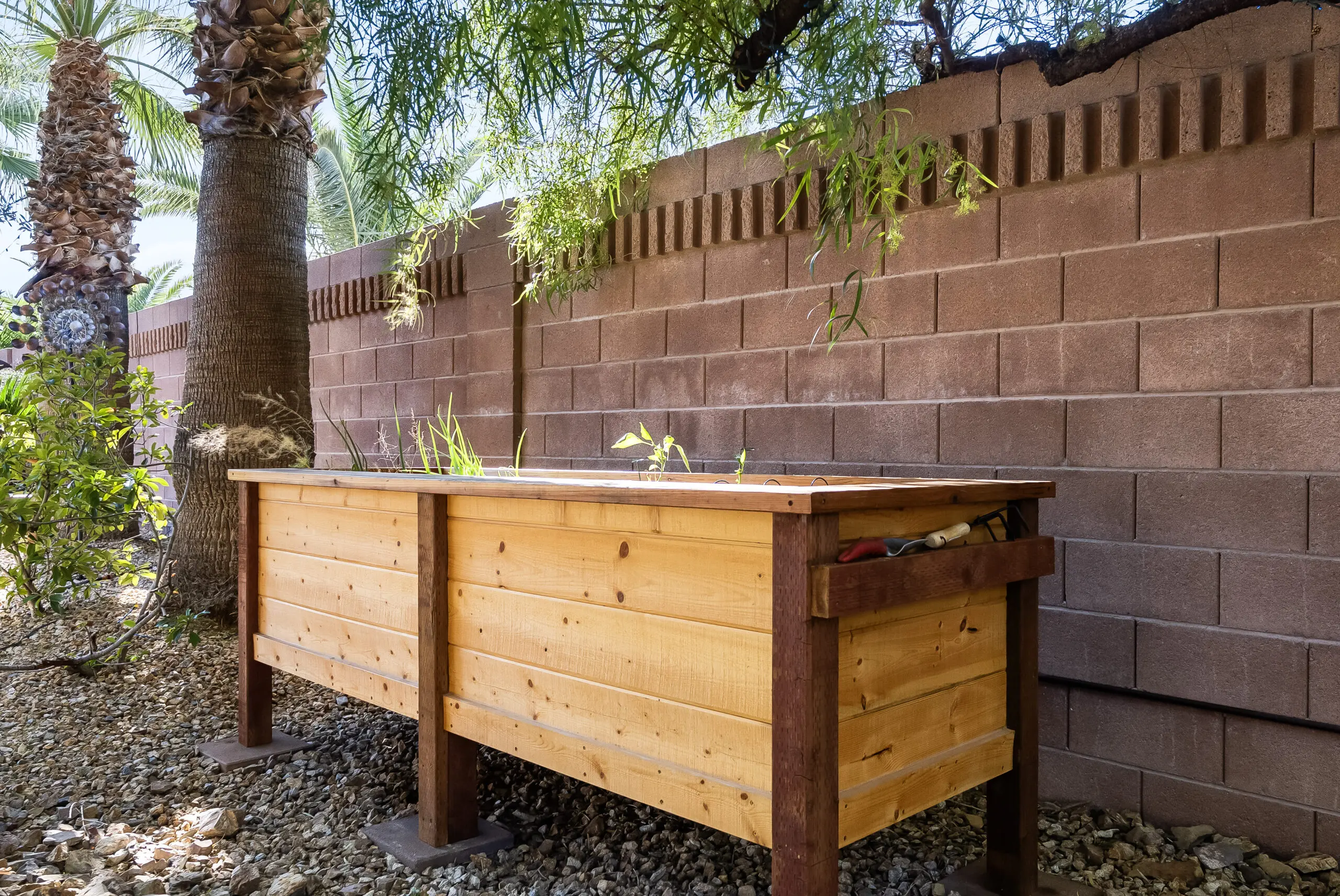 Wooden planter box by brick wall